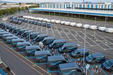 Amazon 'un lojistik merkezine park edilmiş Amazon Prime elektrik dağıtım kamyonlarının en üst görüntüsü. Torino, İtalya - Temmuz 2022