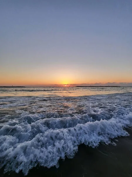 落日时海浪冲刷沙滩的垂直方向 — 图库照片