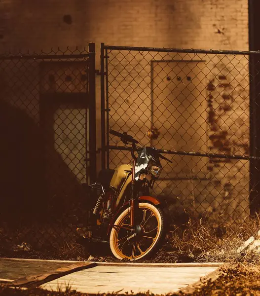 Вертикальный Винтажный Снимок Мотоцикла Опирающегося Забор — стоковое фото