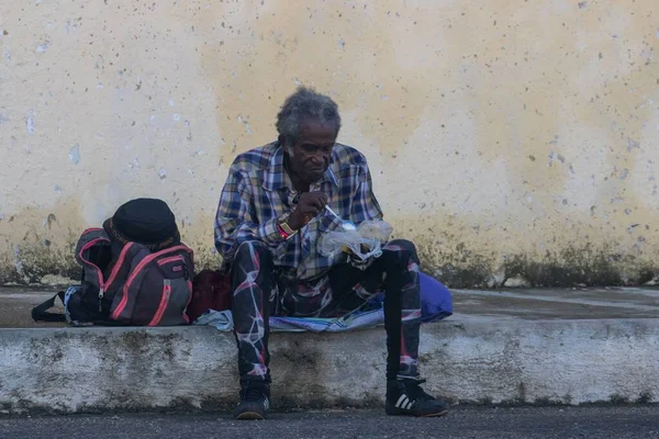 Пожилой Человек Сидит Тротуаре Ест Уличную Еду — стоковое фото