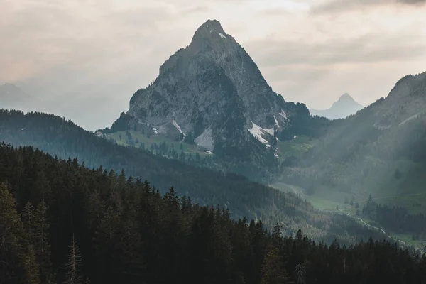 Een Puntige Berg Omringd Door Beboste Heuvels Tegen Een Morgen — Stockfoto