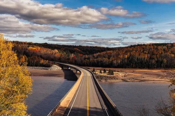 青空の下 秋の晴れた日に田園地帯を横断する長い中断された高速道路の眺め — ストック写真
