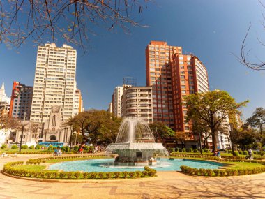 Ağaçlar, çeşmeler, mavi gökyüzü ve güzel konutlar ve ticari binalar. Belo Horizonte şehrinin merkezi panorama. Raul Soares Meydanı.