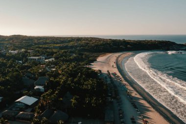 Meksika 'daki yemyeşil yemyeşil kumsala düşen deniz dalgalarının hava görüntüsü.