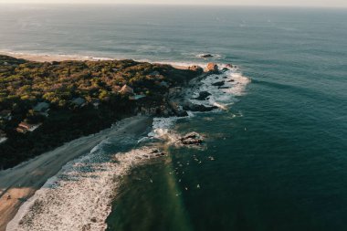 Puerto Escondido, Meksika 'daki kayalık kayalıklara çarpan deniz dalgalarının hava görüntüsü.