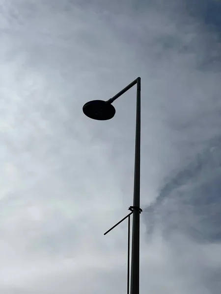 Низкоугольный Вертикальный Снимок Одного Столба Лампы Облачный День Красивым Небом — стоковое фото