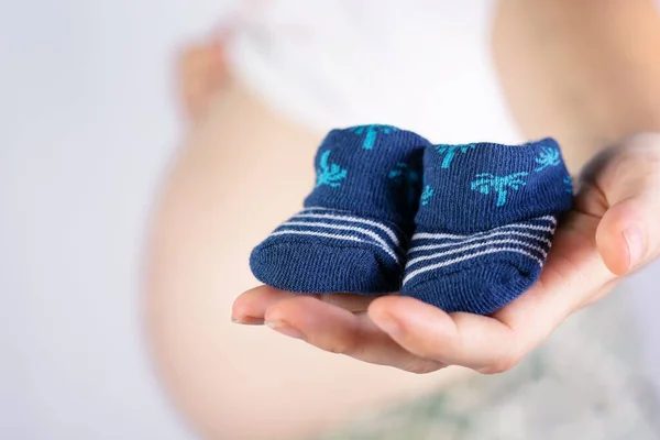 Eine Nahaufnahme Der Hand Einer Frau Die Babysocken Mit Schwangerschaftsbauch — Stockfoto