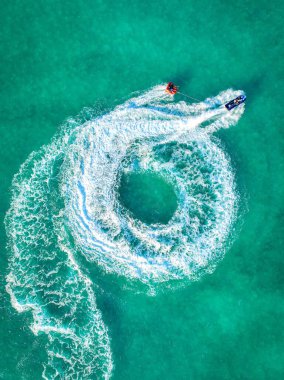 Denizde jet ski oynayan insanların muhteşem bir manzarası var..