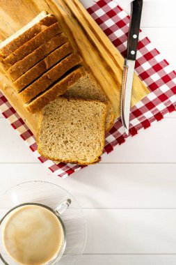 Bir kahvaltı sahnesinde ya da öğleden sonra kahve molasında, doğal mayalanmalı somun ekmek ya da tam ekmek.