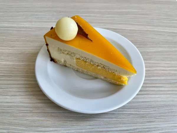 Lezzetli bir tutku meyveli pasta ve beyaz bir tabakta sütlü çikolata süslemesi.