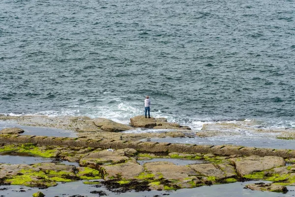 Hombre Está Parado Una Roca Mientras Pesca Mar Whitley Bay — Foto de Stock