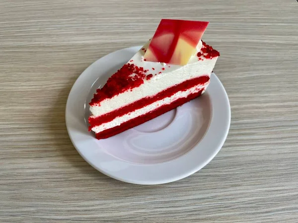 一块红色的天鹅绒蛋糕 上面装饰着一块白色的巧克力 放在木制桌子上 — 图库照片