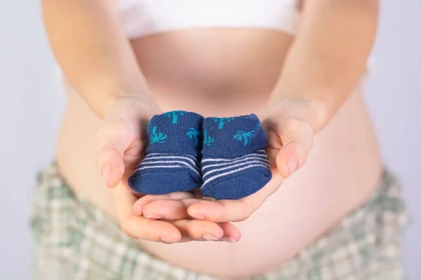 Closeup Female Hands Holding Baby Socks Pregnant Belly — Stock Photo, Image