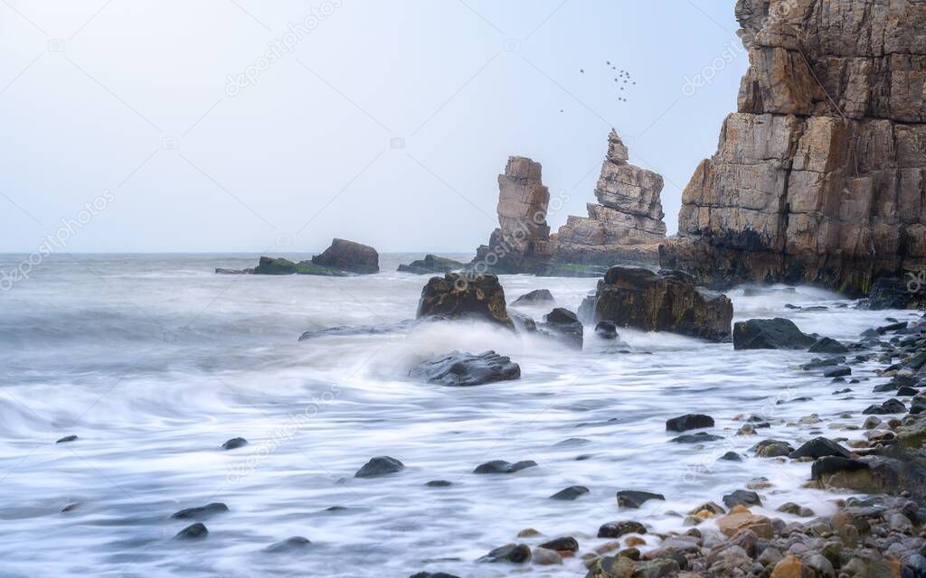 Magnificent seascape with steep waves crashing against the rocky shore and general stone of Dalian, China. The Dalian's most beautiful coastline