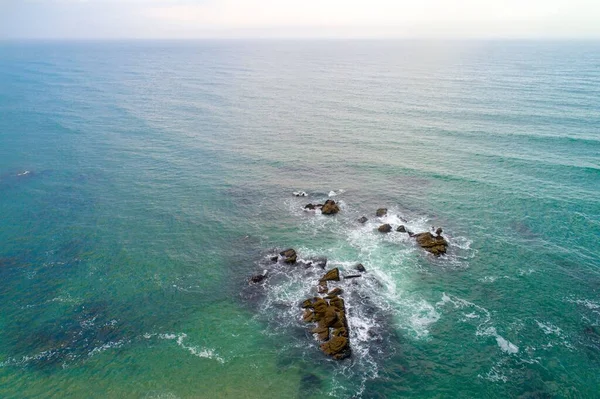 ターコイズブルーの海を持つビーチの岸にある岩の禅の空中風景 — ストック写真
