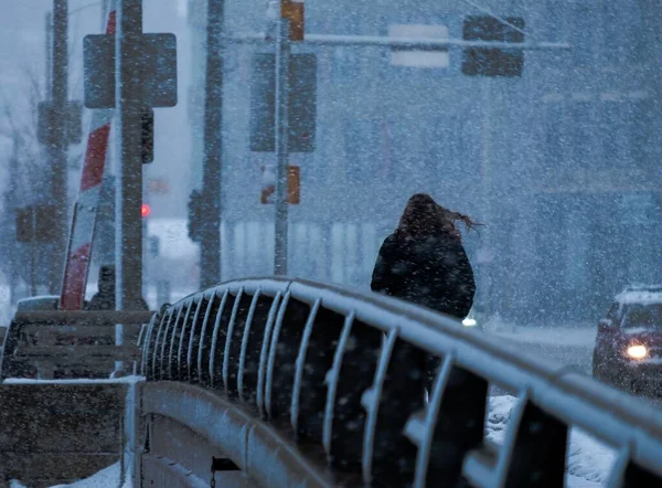 ミルウォーキーの冬の吹雪の時に橋を渡って歩く女性 — ストック写真