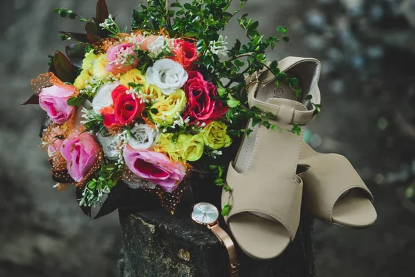 一双棕色的凉鞋 一块手表 木制树桩上的一束五颜六色的花 — 图库照片