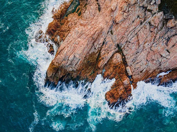 Een Antenne Bovenaanzicht Van Zee Golven Spetterend Tegen Bruine Kliffen — Stockfoto