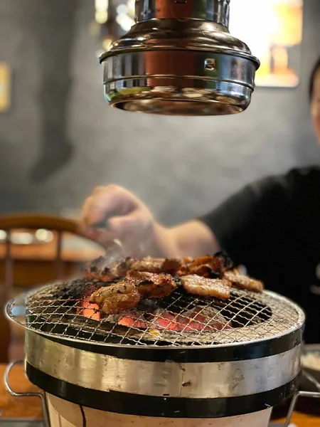 レストランのテーブルグリルで肉を調理する人の垂直ショット — ストック写真