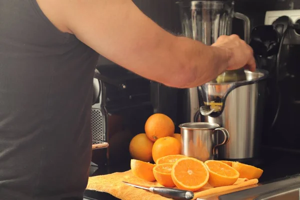 ジューサーでオレンジジュースを作る男のクローズアップ — ストック写真