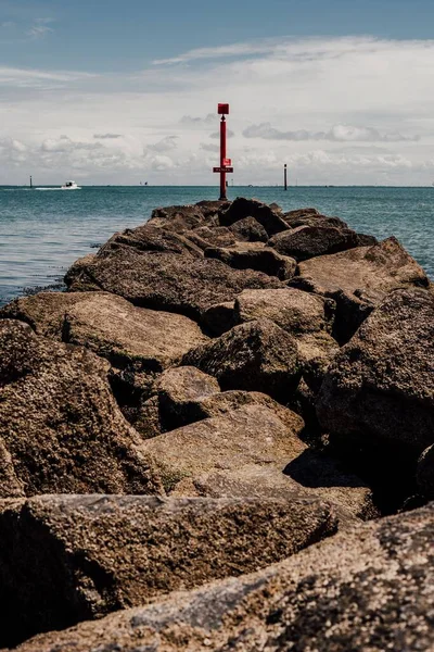 Vertikal Bild Fyrstolpe Stenig Strand Mot Ett Hav — Stockfoto