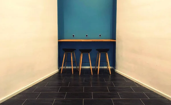 Egy Szimmetrikus Felvétel Egy Kék Falról Asztallal Székekkel — Stock Fotó