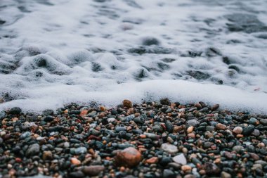 Kayalık bir sahilde köpüklü yumuşak okyanus dalgaları