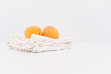 Pamuk mutfak bezli beyaz masa ve kopyalama alanı olan organik meyveler.