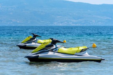 Arka planda dağlar olan bir çift jet ski.