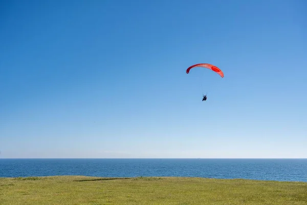 Paraglider Letící Obloze Nad Zelenou Loukou Modrým Mořem — Stock fotografie