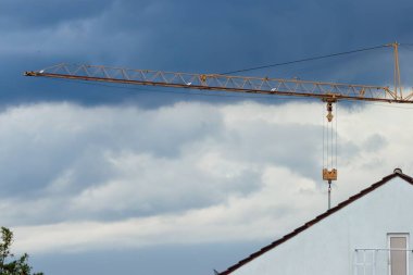 Bulutlu mavi gökyüzüne karşı şantiyede güzel bir vinç manzarası.