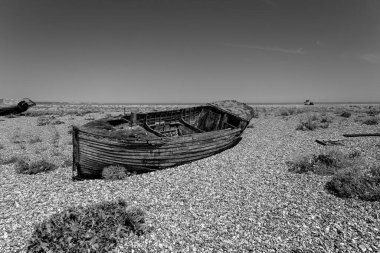 Kumsaldaki ahşap bir yelkenlinin gri tonlu görüntüsü.