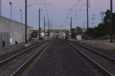 Yanlarında ağaçlar olan bir tren yolu.