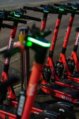 Elektrikli scooter 'ların dikey çekimi. Şehir caddesinde bir otoparkta.