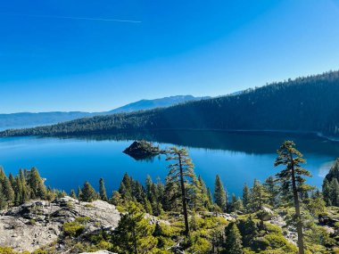 Sudaki ağaçların yansımasıyla sakin gölün güzel bir manzarası.