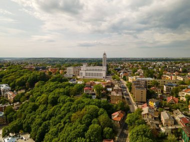 Kaunas İsa 'nın Diriliş Bazilikası' nın güzel manzarası. Ağaçlar ve diğer binalarla çevrili Katolik kilisesi.