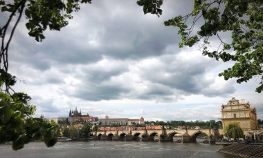 Çek Cumhuriyeti Prag 'da yağmurlu havalarda Charles Köprüsü ve çevresindeki binaların panoramik bir görüntüsü.
