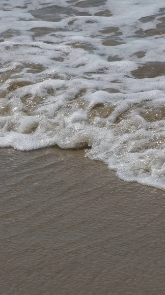 Colpo Verticale Morbida Onda Oceanica Con Schiuma Una Spiaggia Sabbia — Foto Stock