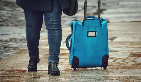 Nahaufnahme Der Beine Einer Person Und Eines Blauen Gepäcks — Stockfoto