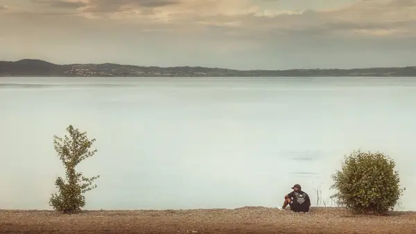 Μια Όμορφη Θέα Ενός Άνδρα Που Κάθεται Στην Αμμώδη Ακτή — Φωτογραφία Αρχείου
