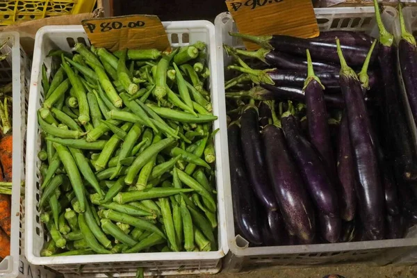 Satılık Sepetlerde Bayanların Parmaklarının Bamya Patlıcanlarının Yakın Plan Fotoğrafı — Stok fotoğraf