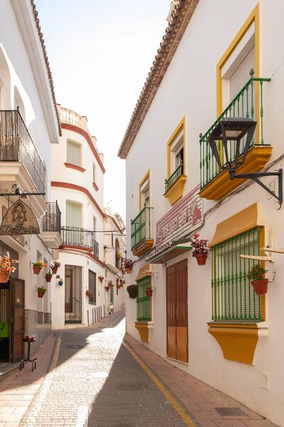 Estepona, Malaga, Spain - June 08, 2022: A typical street in old city Estepona with colorful flower pots. Estepona, Andalusia, Spain