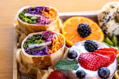 Bir tepside çeşitli meyveler, paketler ve tatlılar.