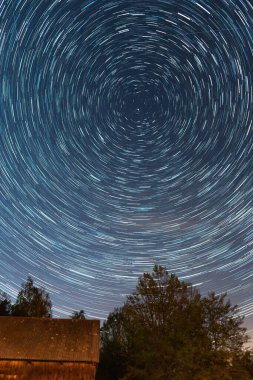 Gökyüzündeki yıldızların uzun pozlu bir görüntüsü.