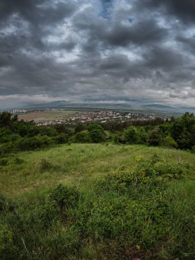 Yağmurlu atmosferi olan bir dağ çayırından köy manzarası.