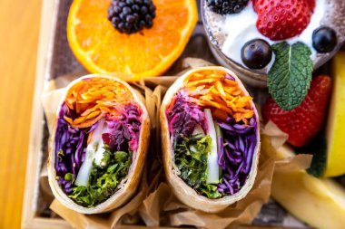 Tabakta çeşitli meyveler, peynir, ekmek ve tatlılardan oluşan yakın plan.