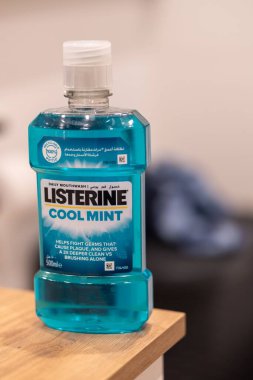 Listerine markası Havalı Naneli Ağız Yıkama plastik bir şişede Tahta bir masada duruyor.
