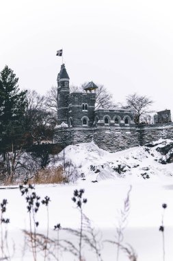 New York, Central Park 'ta kışın karla kaplı Belvedere Kalesi' nin dikey bir görüntüsü.