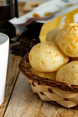 Peynirli ekmeği kapat ya da Brezilya Pao de queijo 'sunu. Kahve çekirdekleri ahşap masanın üzerinde. dikey resim