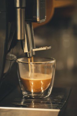Kahve makinesinden bir fincana espresso döküldü.